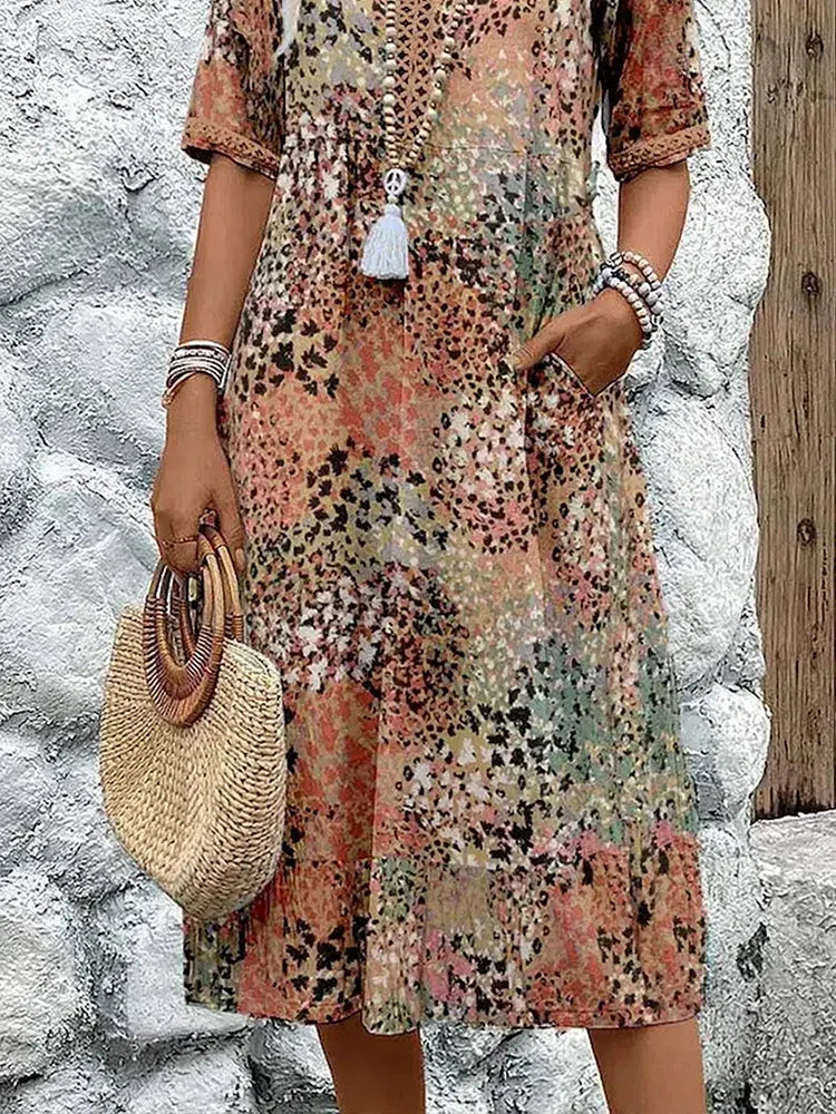 Close-up of the beige print dress showing the side pocket and gathered waist seam detail