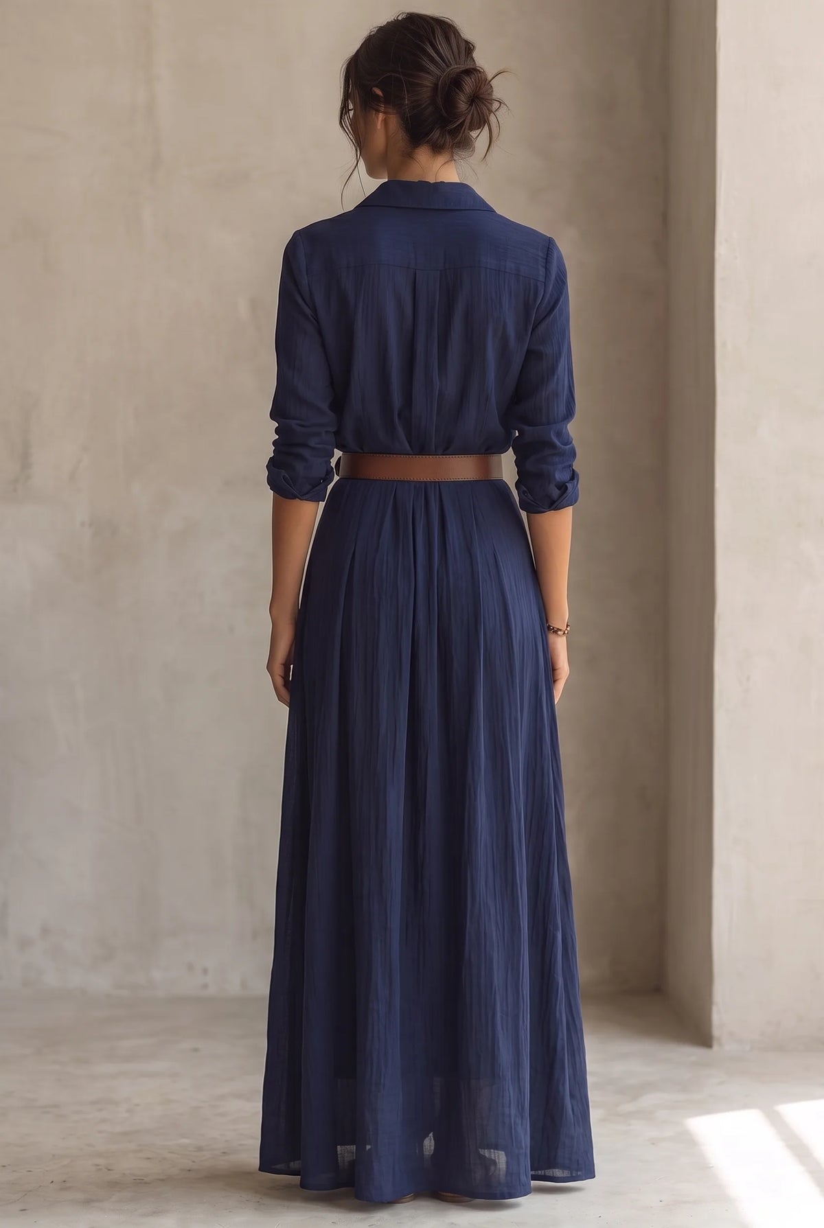 Back view of the navy maxi dress showing the collared yoke, long sleeves and brown waist belt