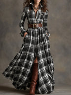 Front view of a black and white check belted shirt dress with pleated maxi skirt and brown boots
