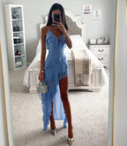 Close front view of the blue ruffle maxi dress showing the V neckline, thin straps and diagonal tiered ruffle skirt detail.