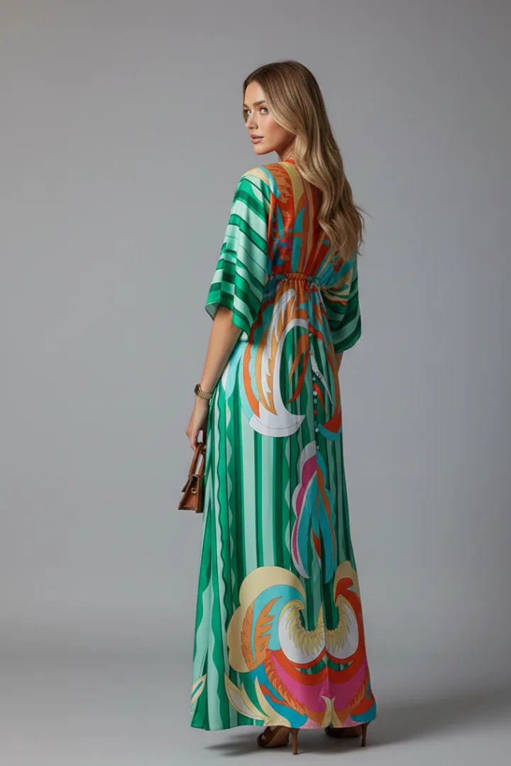 Back view of a model in the green printed maxi dress, showing the relaxed drape and gathered waist detail from behind