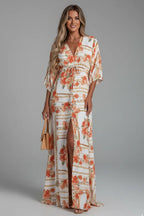 Model wearing the apricot colourway featuring a floral and chain print with button-front detail and side slit