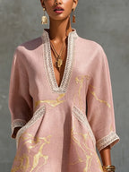 Close-up of crochet lace V-neckline and lace-trimmed pocket on pink mini dress, showing gold marble pattern and fabric texture