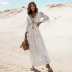 Full-length front view of the lace maxi dress with tiered skirt, tassel necklace detail and pearl-embellished sandals