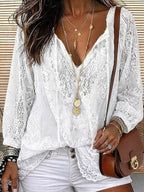 White lace blouse with V-neck and crochet trim, worn with white shorts, silver bangles and gold jewellery