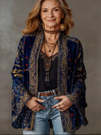 Woman wearing a midnight blue and gold paisley velvet kimono jacket open over a black top, front view