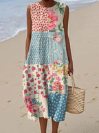 Front view of pink and blue patchwork floral midi dress with sleeveless cut, worn on a sandy beach