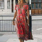 Full-length front view of the red tribal print maxi dress styled with layered boho jewellery on a city street
