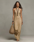 Khaki linen halter maxi dress shown on model walking, fitted bodice flowing into a long slim skirt