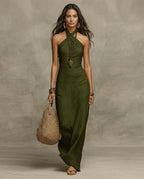 Olive green linen halter maxi dress with open-shoulder cut, worn with hoop earrings and a knotted bag