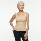 Front view of a woman wearing the square-neck built-in bra tank top in a beige tone with dark pants