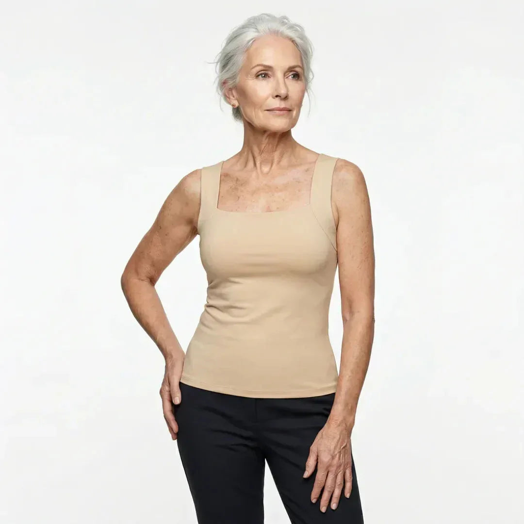 Front view of a woman wearing the square-neck built-in bra tank top in a beige tone with dark pants