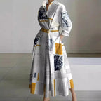 Front view of white maxi shirt dress with black newspaper print, collared neckline and cinched waist