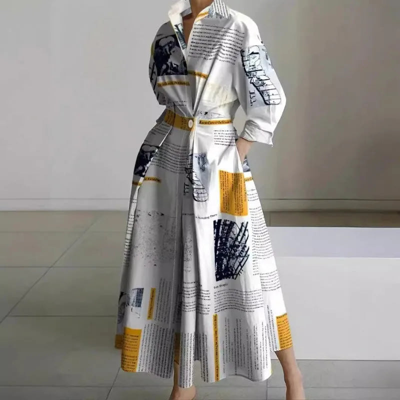 Front view of white maxi shirt dress with black newspaper print, collared neckline and cinched waist