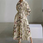 Cream maxi shirt dress with floral and chain print, voluminous sleeves and side pockets, styled with heels