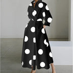 Black maxi shirt dress with bold white polka dot print and tied waist, worn with heels