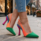 Green and orange slingback pump with hot pink, blue and magenta stiletto heel, shown walking on a paved street
