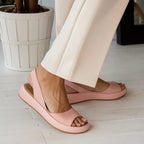 Pink platform slingback sandals shown from behind, highlighting the rounded heel cup and elasticated ankle strap.