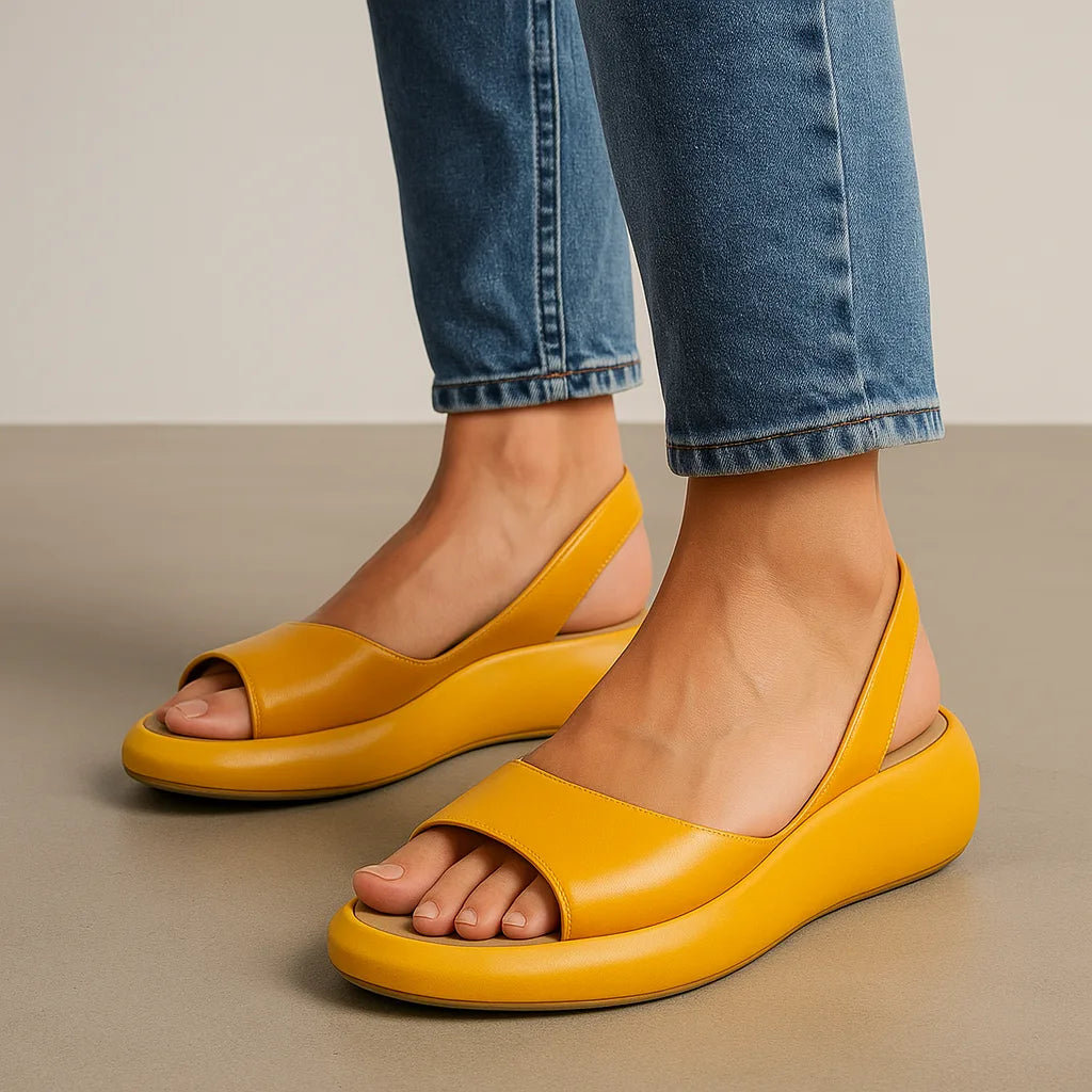 Mustard yellow platform slingback sandals worn with cuffed denim jeans, side view showing the chunky sole.