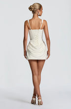 Back view showing the ivory dress's lace-up corset back detail and adjustable straps