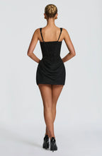 Back view of the black mini dress showing the lace-up corset back and thin adjustable straps