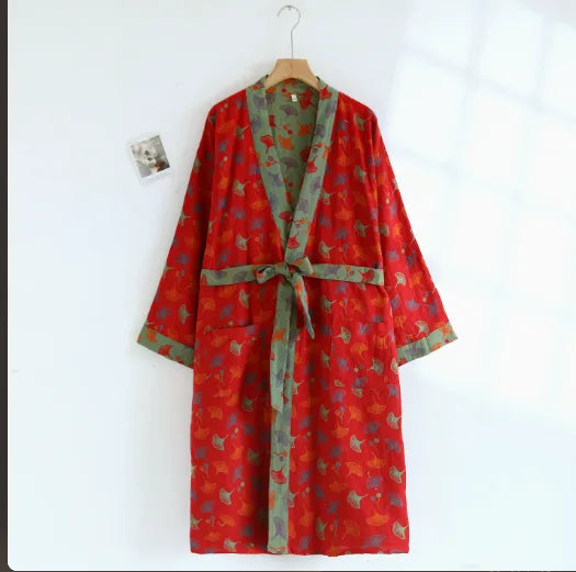 Red cotton kimono robe with botanical leaf print and matching green trim, tied at the waist with patch pockets