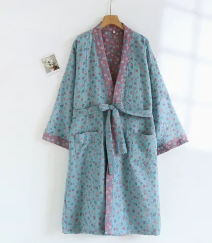 Light blue kimono robe covered in a small pink floral print, with contrasting pink reversible lining and tie