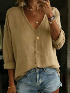 Khaki cotton linen shirt with soft V-neckline and horn-style buttons worn over denim shorts.