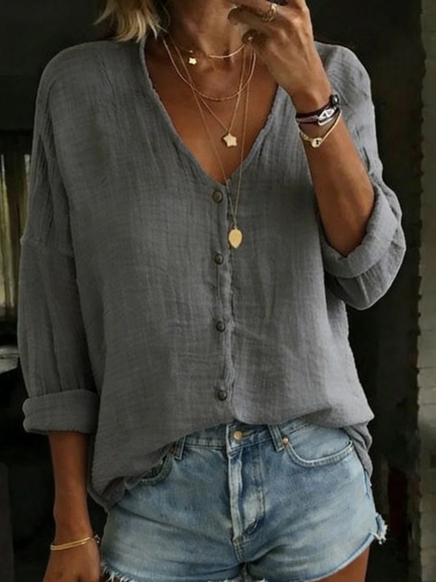 Grey cotton linen blouse with visible woven texture, button placket and casual oversized silhouette.