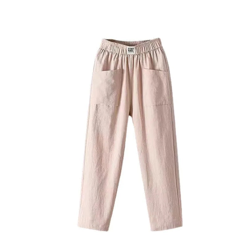 Flat lay of pale pink cotton linen pants showing the elastic waistband label and dual front pockets