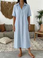 Light blue linen blend polo dress with patch details and relaxed A-line fit shown against a neutral wall