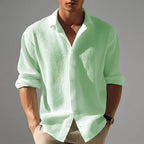 Man modelling the shirt in a soft mint green shade with white collar contrast, sleeves rolled to the forearm