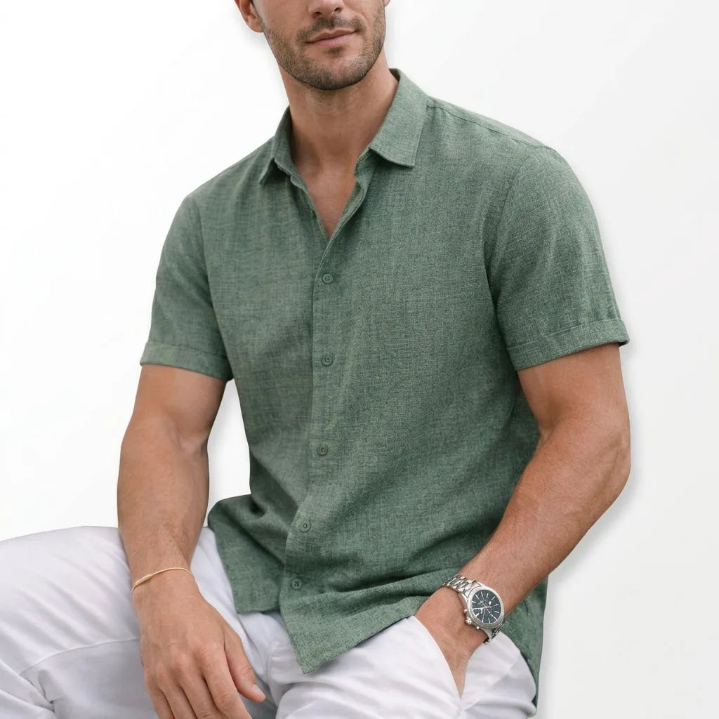 Close-up of a sage green textured cotton shirt with rolled short sleeves and classic collar