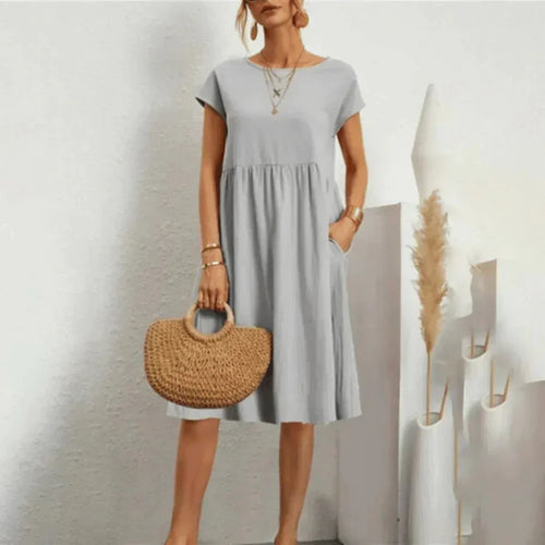 Grey relaxed-fit midi dress with cap sleeves and a round neckline, styled with layered gold necklaces