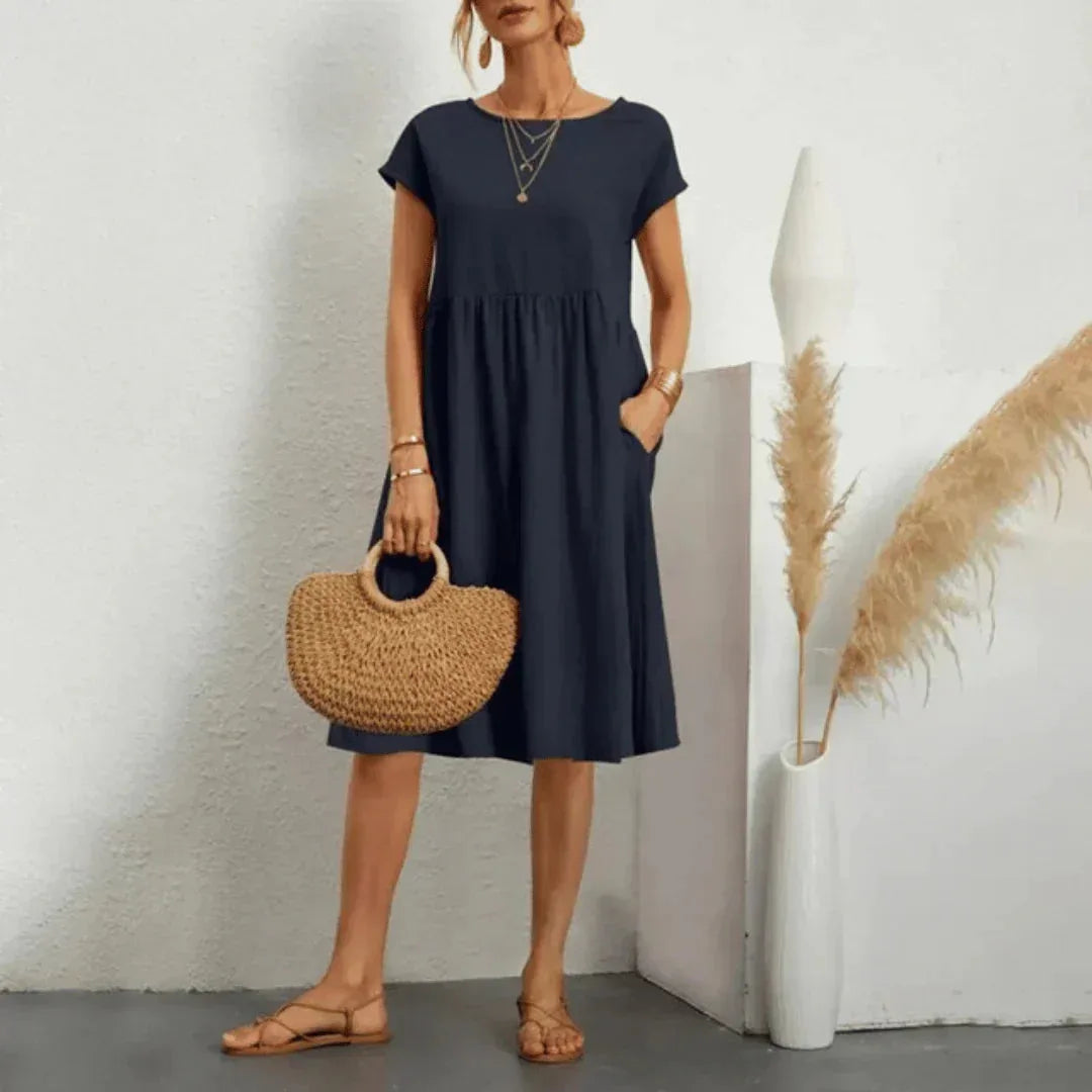 Navy swing dress with dropped shoulder cap sleeves and gathered empire waist, shown full length