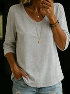 Light grey marle V-neck T-shirt with three-quarter length sleeves, shown with a leather bracelet stack and distressed jeans