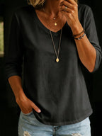 Charcoal black V-neck T-shirt with relaxed three-quarter sleeves and a curved hem, paired with a pendant necklace