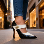 Front angled view of black croc-print pointed-toe heel with cream T-strap and gold buckle detail