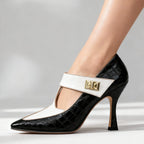 Studio shot of black and white croc-embossed T-strap heel showing pointed toe and sculpted stiletto heel