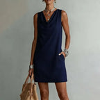 Side-angle view of a sleeveless mini dress showing the hand placed in the practical side pocket