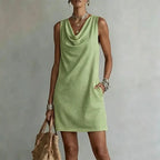 Pale green sleeveless mini dress showing the loose shift silhouette and hemline above the knee
