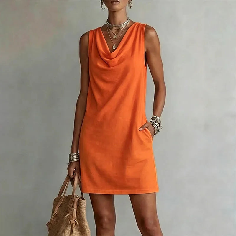 Close view of an orange sleeveless mini dress highlighting the soft fabric drape at the neckline