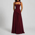 Front view of a burgundy satin maxi dress with square neckline, structured corset waist and softly draped asymmetric skirt