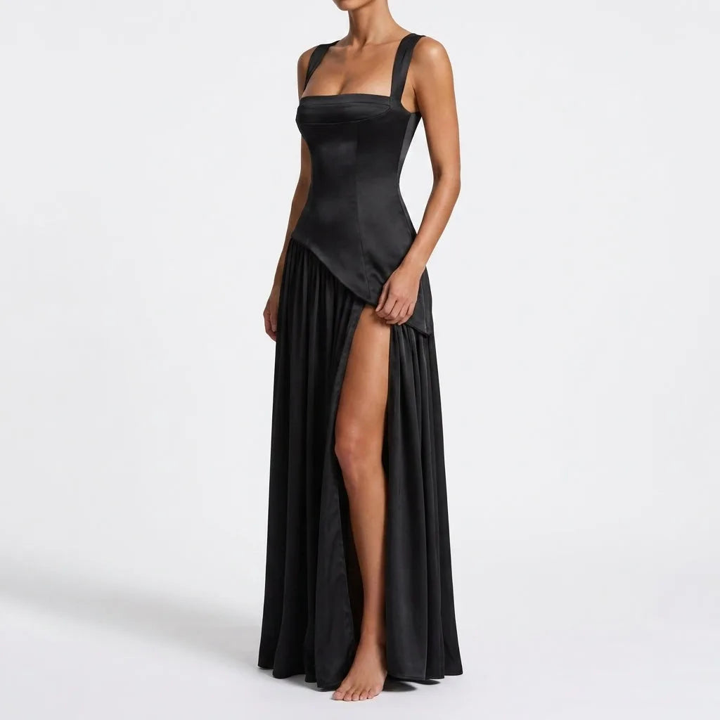 Side profile of a black satin maxi dress highlighting the squared bodice, cinched waist and thigh-high side slit