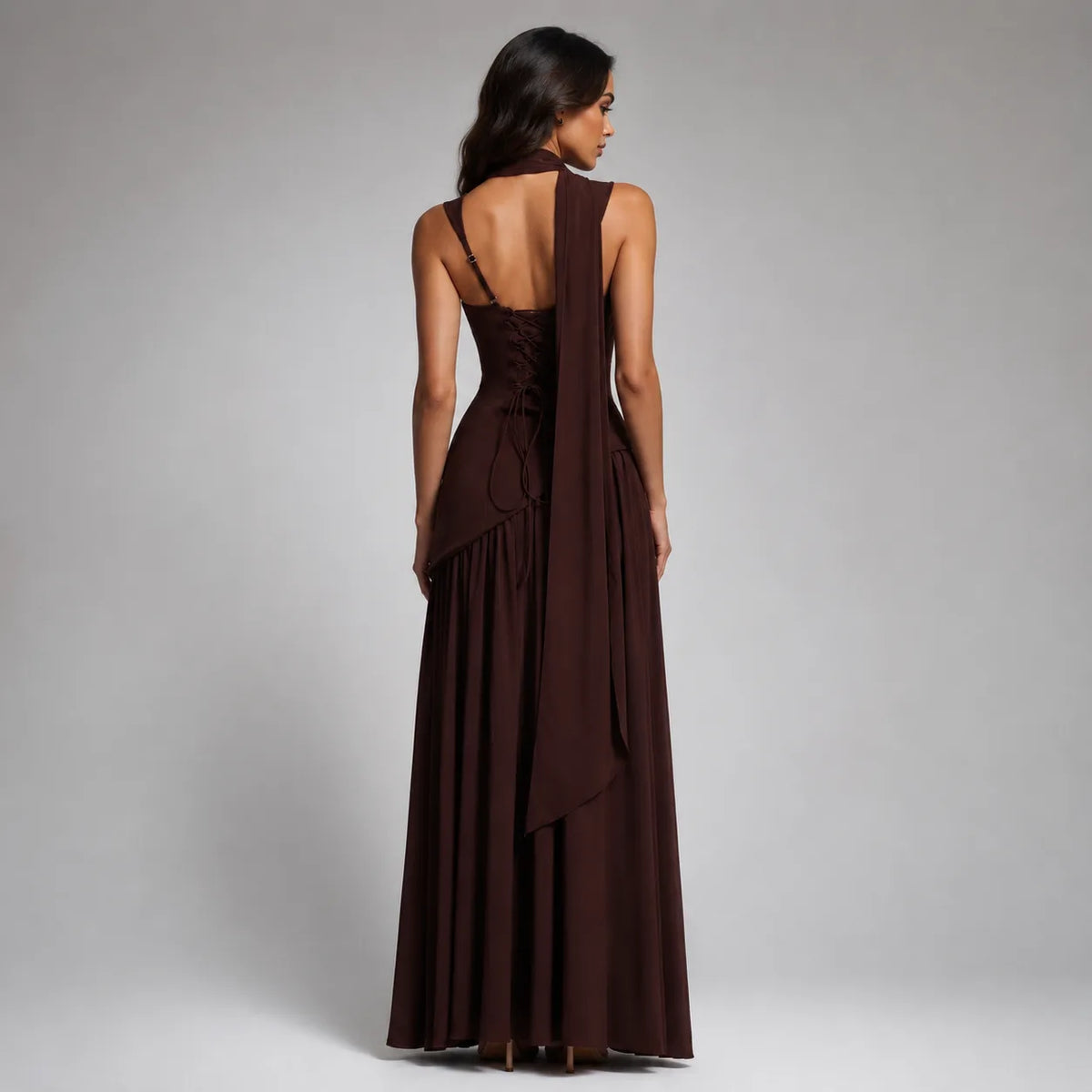 Back view of the chocolate brown dress showing the lace-up corset back, thin straps and long trailing scarf
