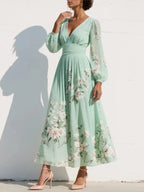 Close-up side profile of the floral midi dress highlighting the sheer blouson sleeve and soft A-line skirt movement