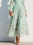 Close-up of the gathered waist and pleated skirt panel showing the floral print placement near the hem
