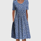 Front view of a navy blue midi dress with a small white floral scatter print, short sleeves and a relaxed A-line skirt