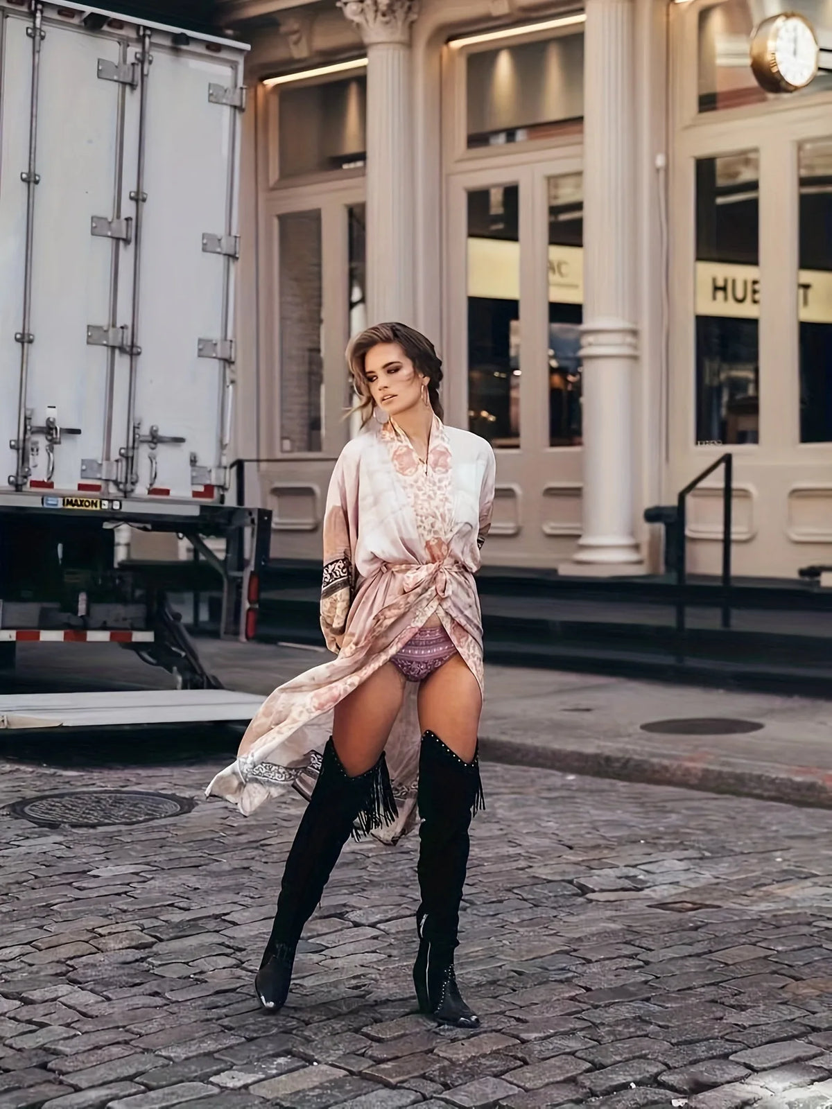 Model adjusting hair while wearing dusty rose floral kimono with bell sleeves in a studio setting