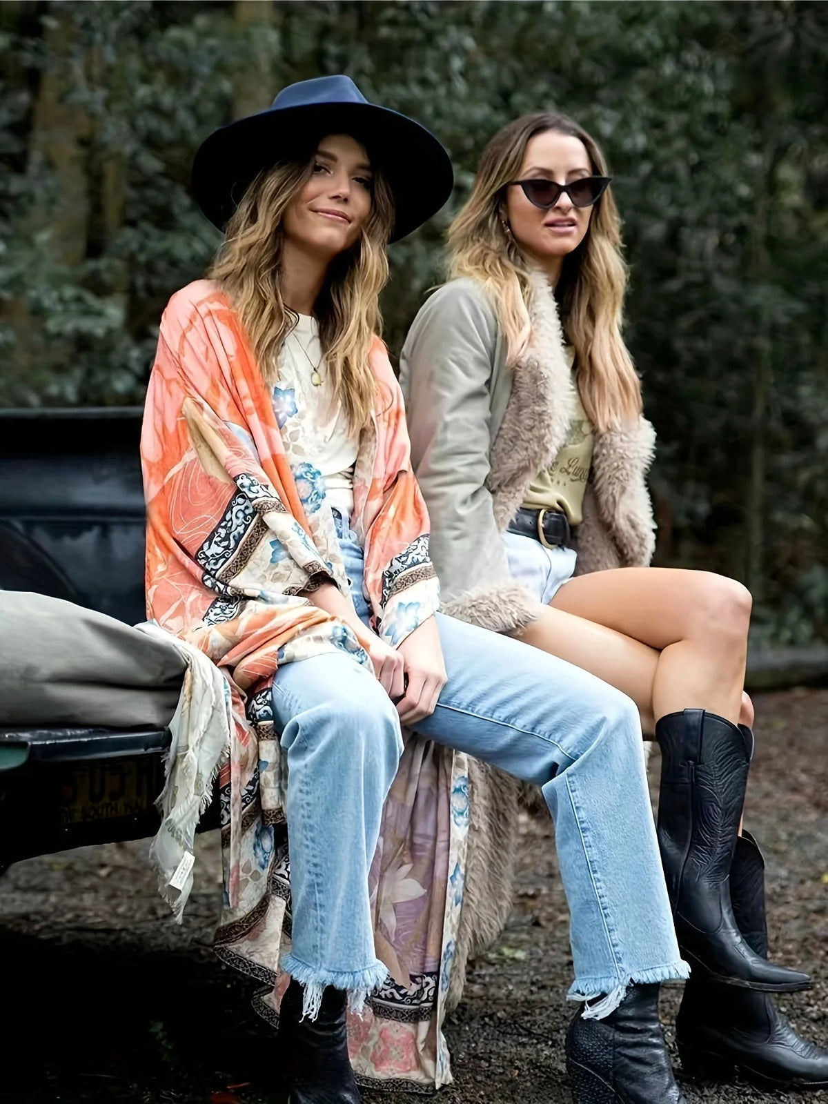 Two friends seated outdoors, one wearing the rust orange floral kimono over jeans and a white tee